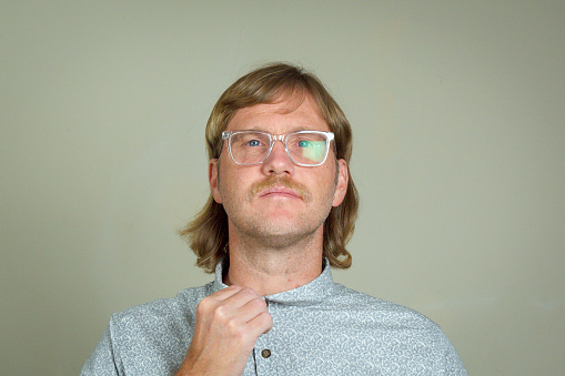 Man with mullet and glasses adjusting collar