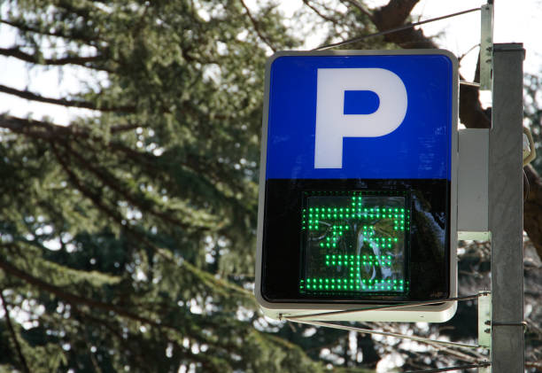 Blue parking sign with a white P, a car graphic on a kerb, and text reading In marked baysindicating restricted parking only within designated areas.