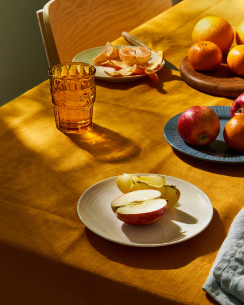 istock Food, breakfast with fruit. Table covering bright yellow linen tablecloth, sunlight deep hard shadow 1304472312