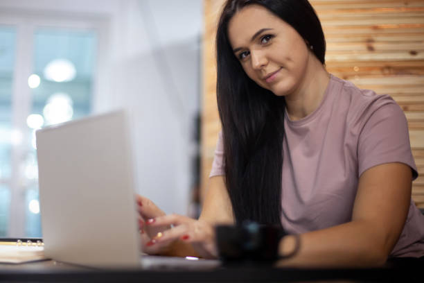 istock Concentrated young woman typing on computer while having a coffee break at her office interior 1304473074