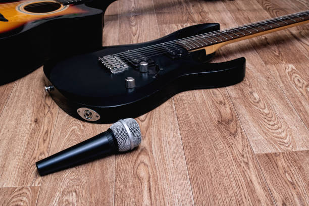 istock Microphone and guitar on a wooden background 1304473204