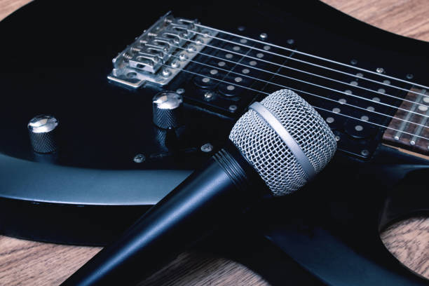istock Microphone and guitar on a wooden background 1304473208