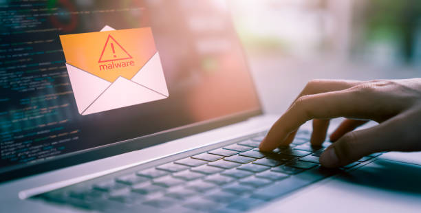 concetto di crimine informatico, uso a mano del laptop e visualizzazione dello schermo di malware fornito con e-mail, password di hacking e dati personali. - spam computer hacker computer keyboard e mail foto e immagini stock