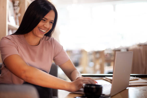 istock Concentrated young woman typing on computer while having a coffee break at her office interior 1304474848