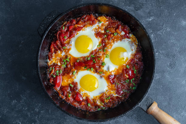 istock Shakshuka, fried eggs with tomatoes, onion, red pepper and spices in cast iron pan 1304475842