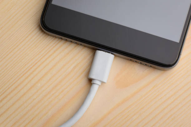 istock lower part of smartphone with plugged on the wire while charging 1304477854