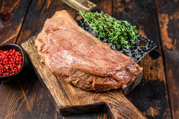 istock Marinated in mustard Marinate beef tri tip steak for bbq. Black background. Top view 1304478517