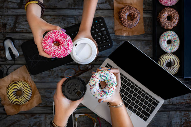 Female employees having their breakfast at the office desk.