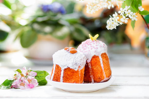 istock Easter Feast. Two decorated Easter cakes on a plate next to an apple blossom. In the background-plants and flowers. Soft focus 1304479777