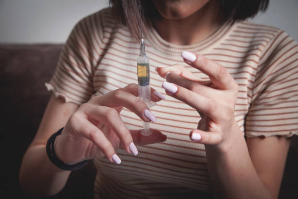 istock Drug addict with a syringe at home. 1304481149