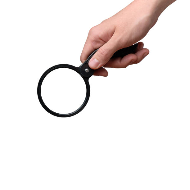 istock Hand holding a magnifying glass isolated. Close up. 1304484792
