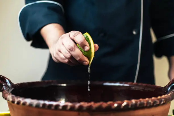 Photo of lime juice falling from the chef's hand in typical Mexican food