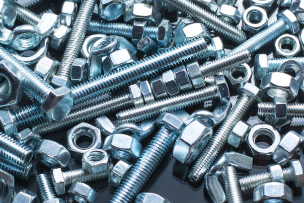 istock Bolts and nuts of different size on black background 1304485825