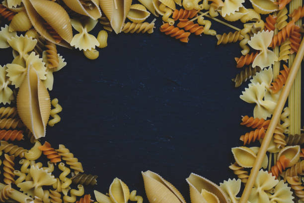 istock Dried mixed pasta on a dark wooden table. 1304486679
