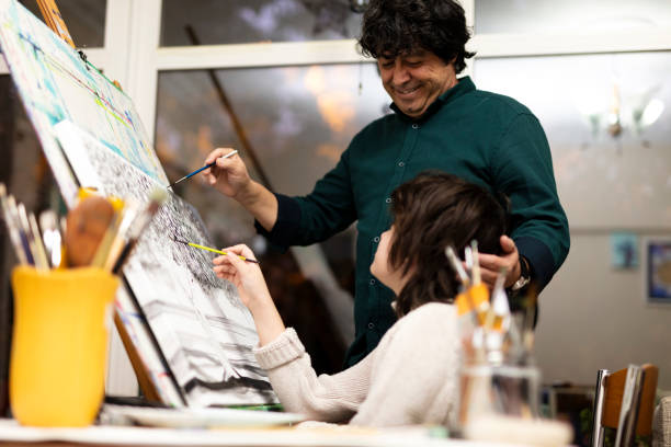 istock Father is encouraging her son while he is painting 1304487016