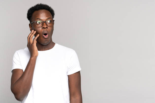 istock Surprised afro man makes big eyes opens, touching her face, shocked with unprecedentedly low prices 1304487029