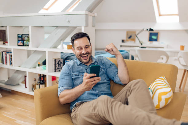 istock Happy man watching something on the smartphone and cheering 1304488058