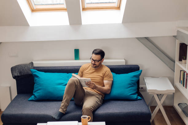 istock Young man reading at his modern living room 1304488151