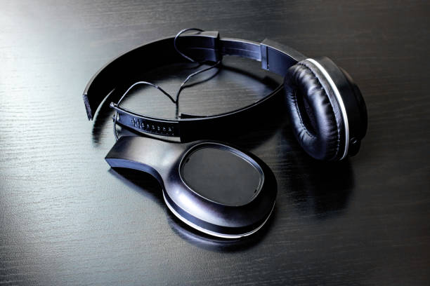 Sleek black over-ear headphones in dramatic spotlight.