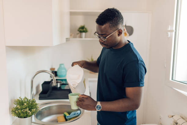 istock African American pouring himself morning coffee 1304488196
