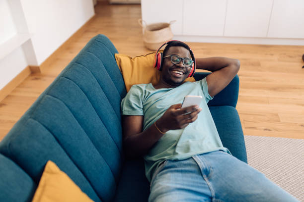 istock Young African man enjoying on the sofa and having fun online 1304488243