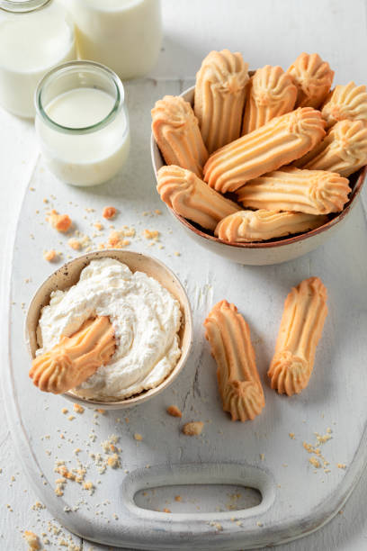 istock Delicious shortbread cookies in old bowl with whipped cream 1304494800