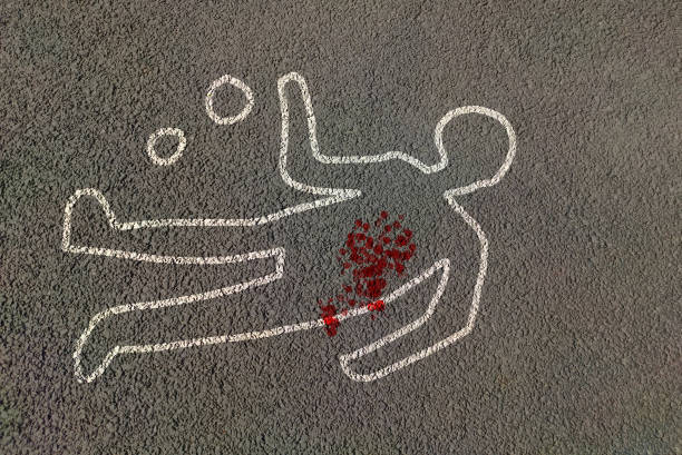 Man silhouette shape outline of dead body marked on road by chalk with evidence circled with blood strain on highway. Victim crime scene man murder body chalk outline by police for forensic investigation on road. assassination photos stock pictures, royalty-free photos & images