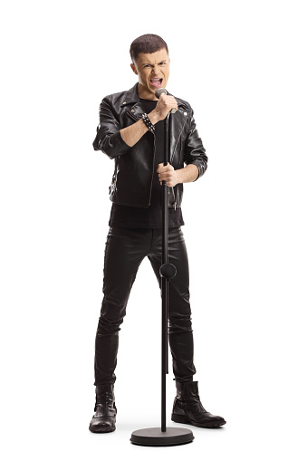 Full length portrait of a young male rock singer with a microphone isolated on white background