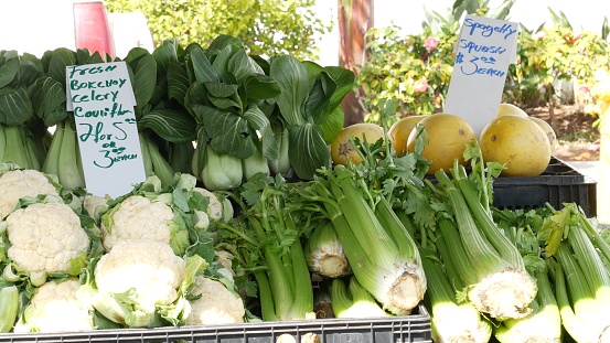 Organic vegetables on counter, fresh local produce homegrown raw veggies on marketplace stall. Healthy vegetarian food, Farmers market in Oceanside California USA. Agricultural farm harvest selling.