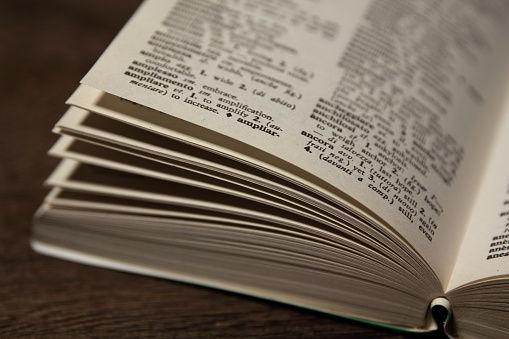 A dictionary opened on a table.  It is useful for a image of studying.