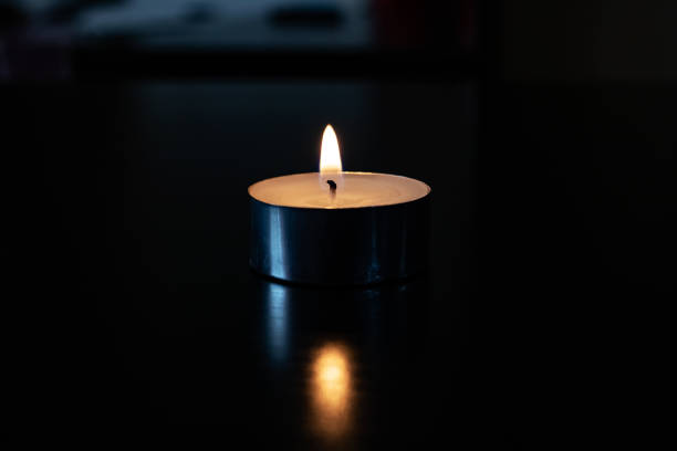 istock Flame of a small candle in the dark 1304500228