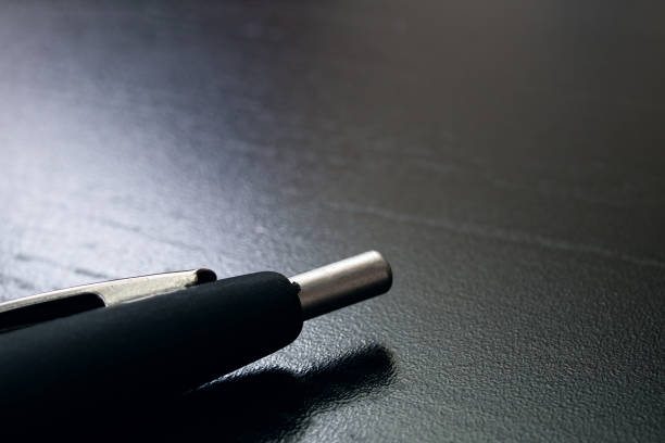 istock Black pen on a black wooden table 1304500246