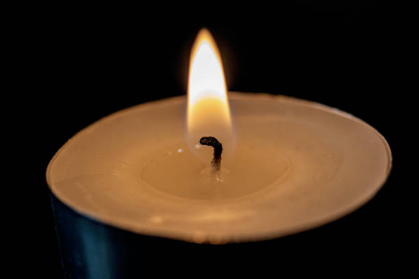 istock Flame of a small candle in the dark 1304500249