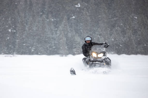 istock Man having fun speeding with a snowmobile through the powder snow 1304500382