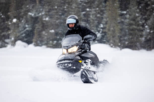 istock Man having fun speeding with a snowmobile through the powder snow 1304500438