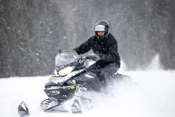 istock Man having fun speeding with a snowmobile through the powder snow 1304500526