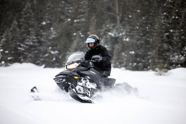 istock Man having fun speeding with a snowmobile through the powder snow 1304500542