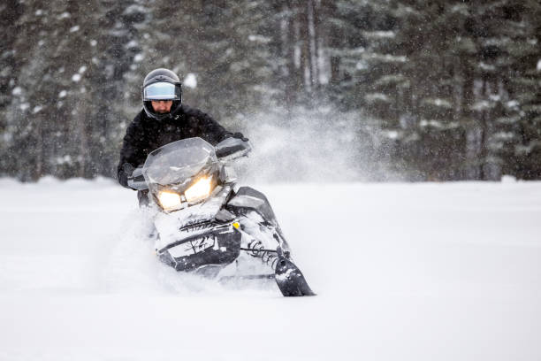 istock Man having fun speeding with a snowmobile through the powder snow 1304500561