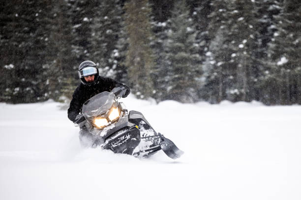 istock Man having fun speeding with a snowmobile through the powder snow 1304500566