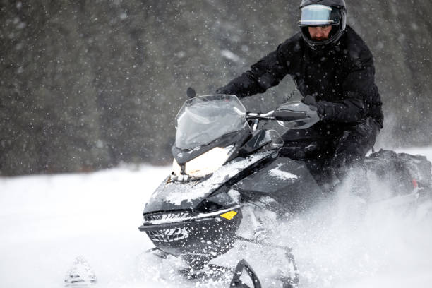 istock Man having fun speeding with a snowmobile through the powder snow 1304500575