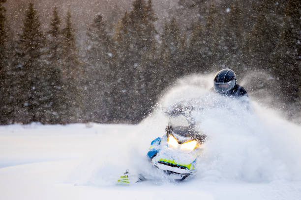 istock Man having fun speeding with a snowmobile through the powder snow at sunset 1304501094