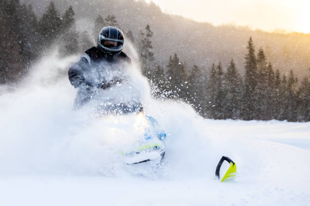 istock Man having fun speeding with a snowmobile through the powder snow at sunset 1304501123