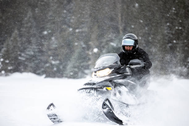 istock Man having fun speeding with a snowmobile through the powder snow 1304501140