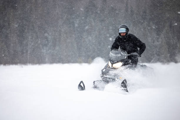 istock Man having fun speeding with a snowmobile through the powder snow 1304501156