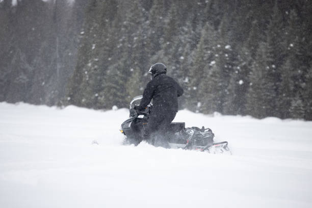 istock Man having fun speeding with a snowmobile through the powder snow 1304501191