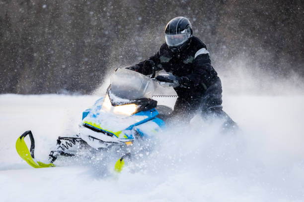 istock Man having fun speeding with a snowmobile through the powder snow at sunset 1304501230