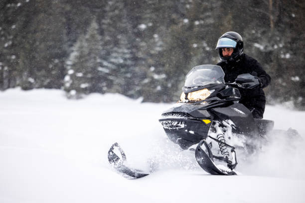 istock Man having fun speeding with a snowmobile through the powder snow 1304501236