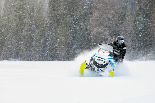 istock Man having fun speeding with a snowmobile through the powder snow at sunset 1304501242