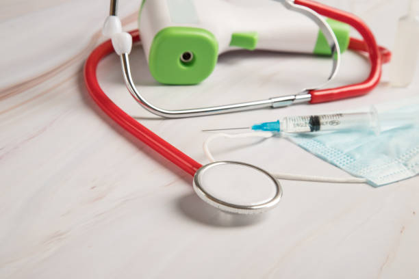 istock Medical devices for vaccination against coronavirus on a light table-a stethoscope, a syringe with a vaccine, a medical mask. Copy space 1304501468