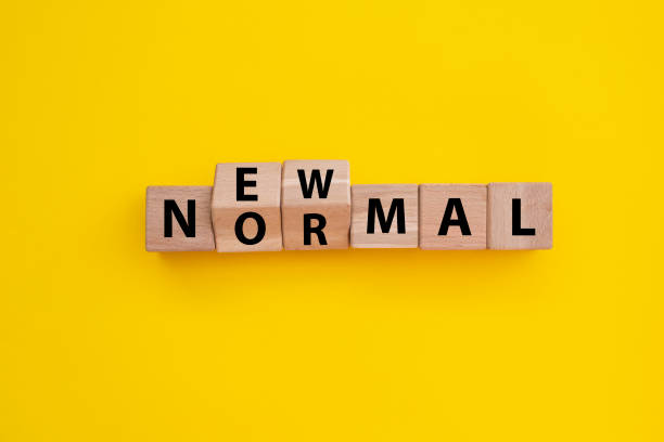 istock New normal word wooden alphabet cube. Yellow background 1304502557